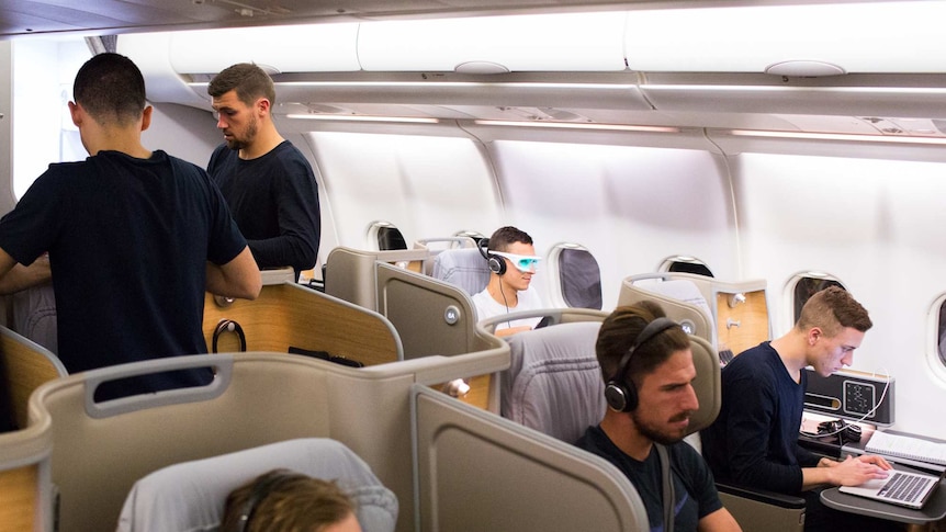 Socceroos relax during flight from Honduras to Australia