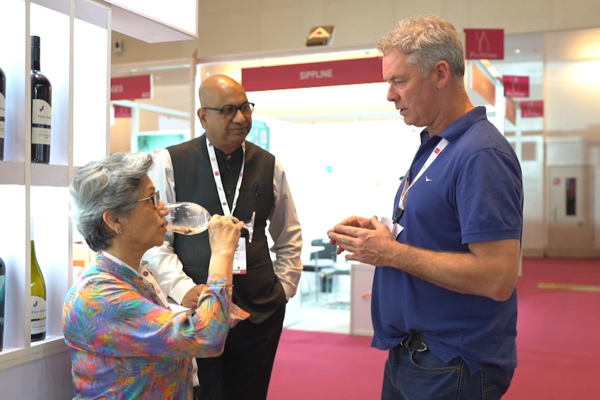 Photo of a man talking to another man about wine.