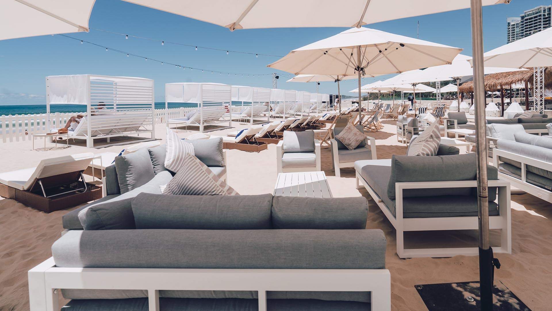 luxury beach cabanas and umbrellas at a day club set up on the sand