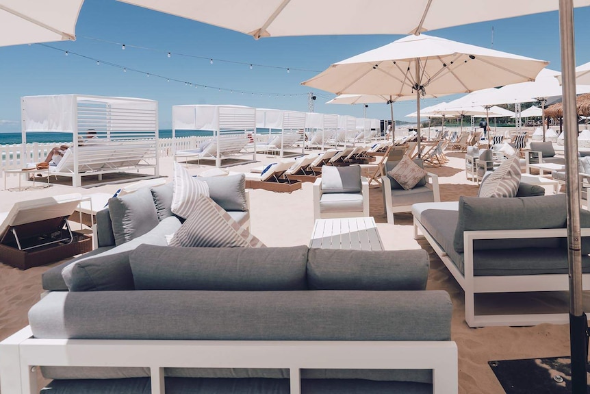 luxury beach cabanas and umbrellas at a day club set up on the sand