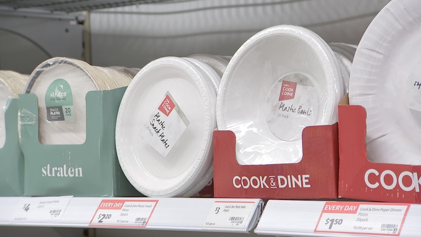 plastic plates on a shelf in a supermarket