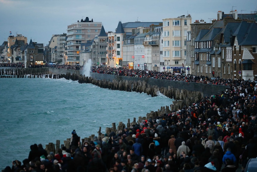 People gather to watch the incoming high tide in Saint Malo