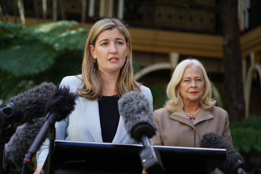 Shannon Fentiman speaking at a media conference, with Margaret McMurdo behind her