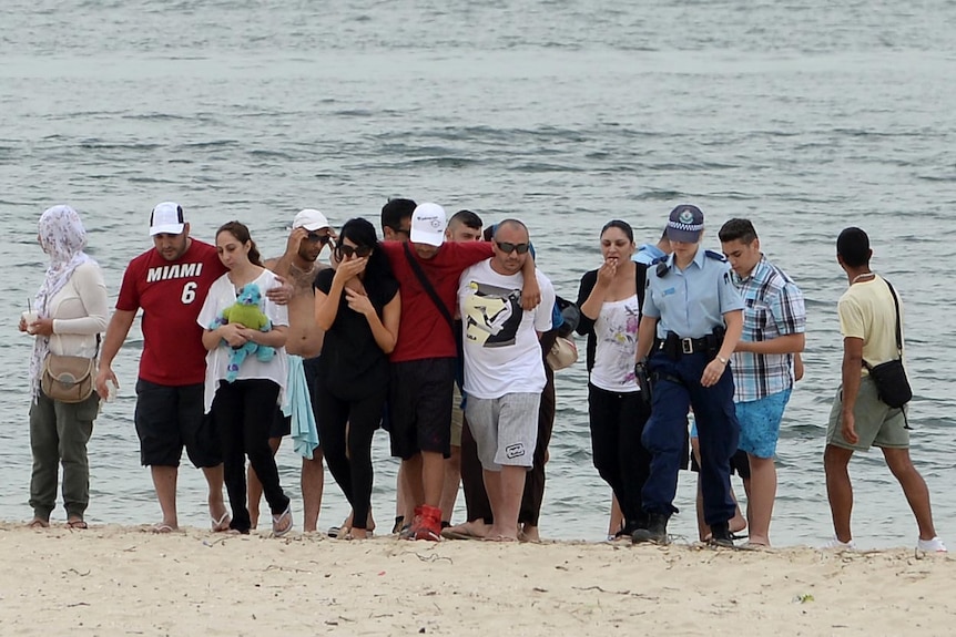 The mother (3rd left) and relatives of Ayman Ksebe return to the scene of his drowning.
