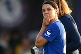 Sam Kerr holds her mouth as she walks off