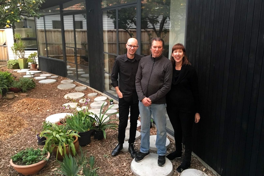 Anthony, Brett and Jennifer stand in front of the newly built home.