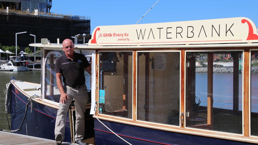 A man leans against a small ferry at Perth's Elizabeth Quay.