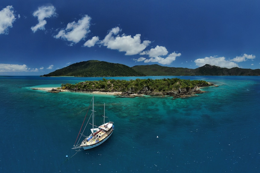 a large boat is floating near an island