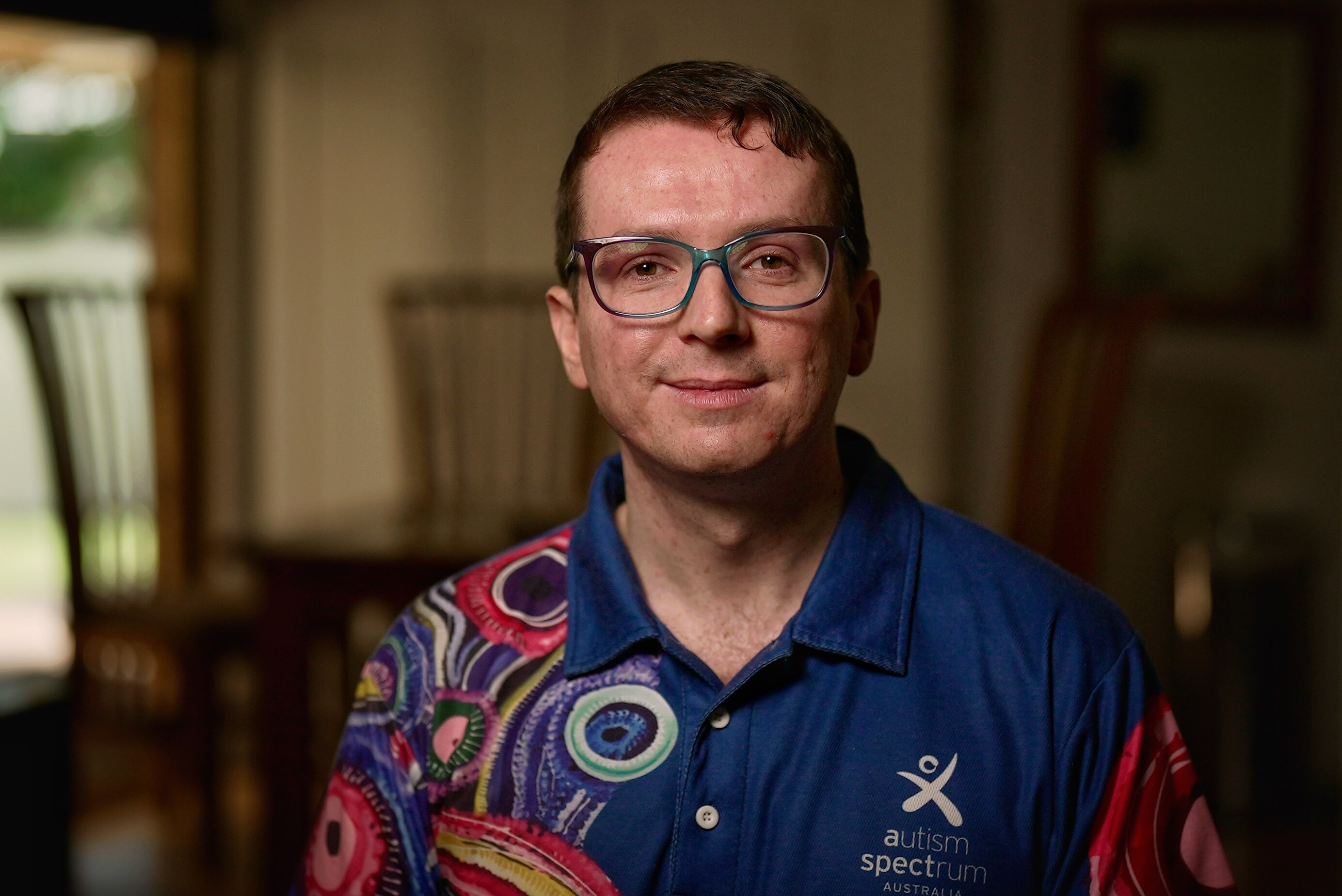 Un hombre con gafas y polo.