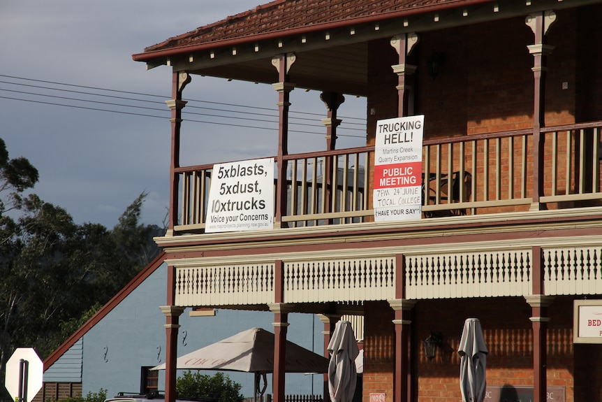 Signs protesting against a quarry expansion hung on the railing of a second-storey balcony.