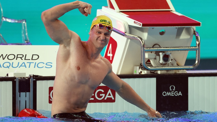 Sam Williamson flexes his significant muscles in the pool after a race