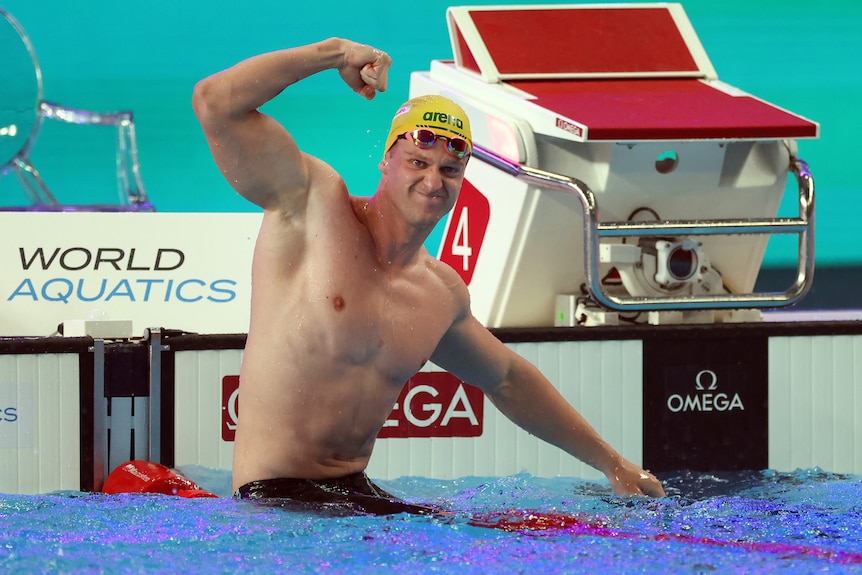 Sam Williamson flexes his significant muscles in the pool after a race