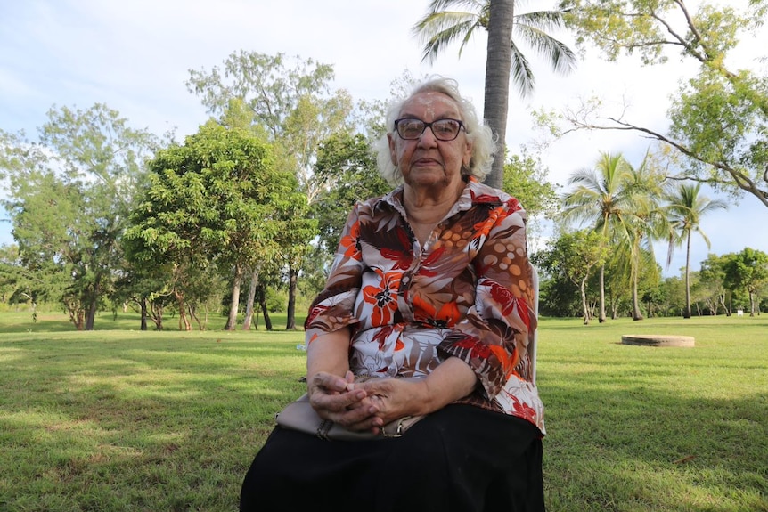 Une femme assise dans un parc.