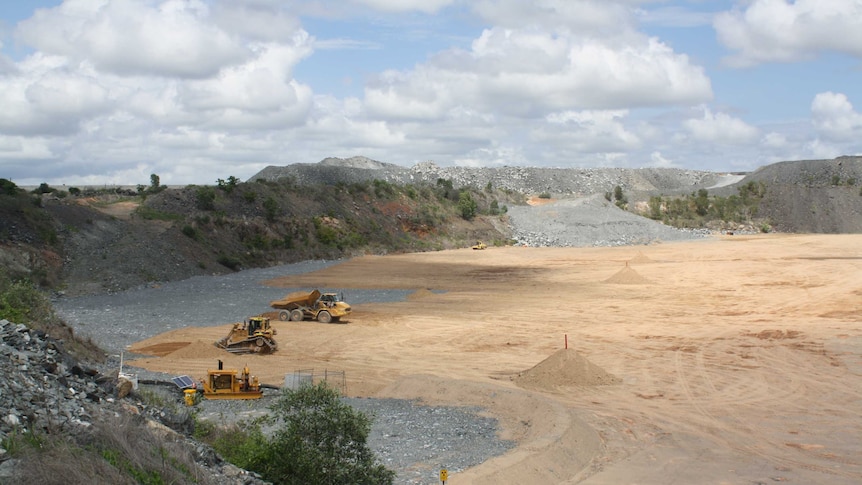 a mine site with a dozer and dumptruck