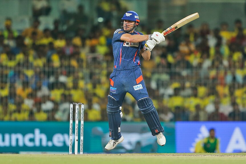 Marcus Stoinis completes his swing as a cricket flies off his bat in the IPL.