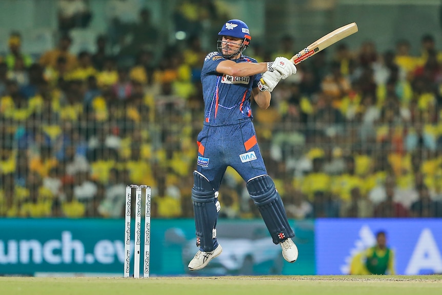 Marcus Stoinis completes his swing as a cricket flies off his bat in the IPL.