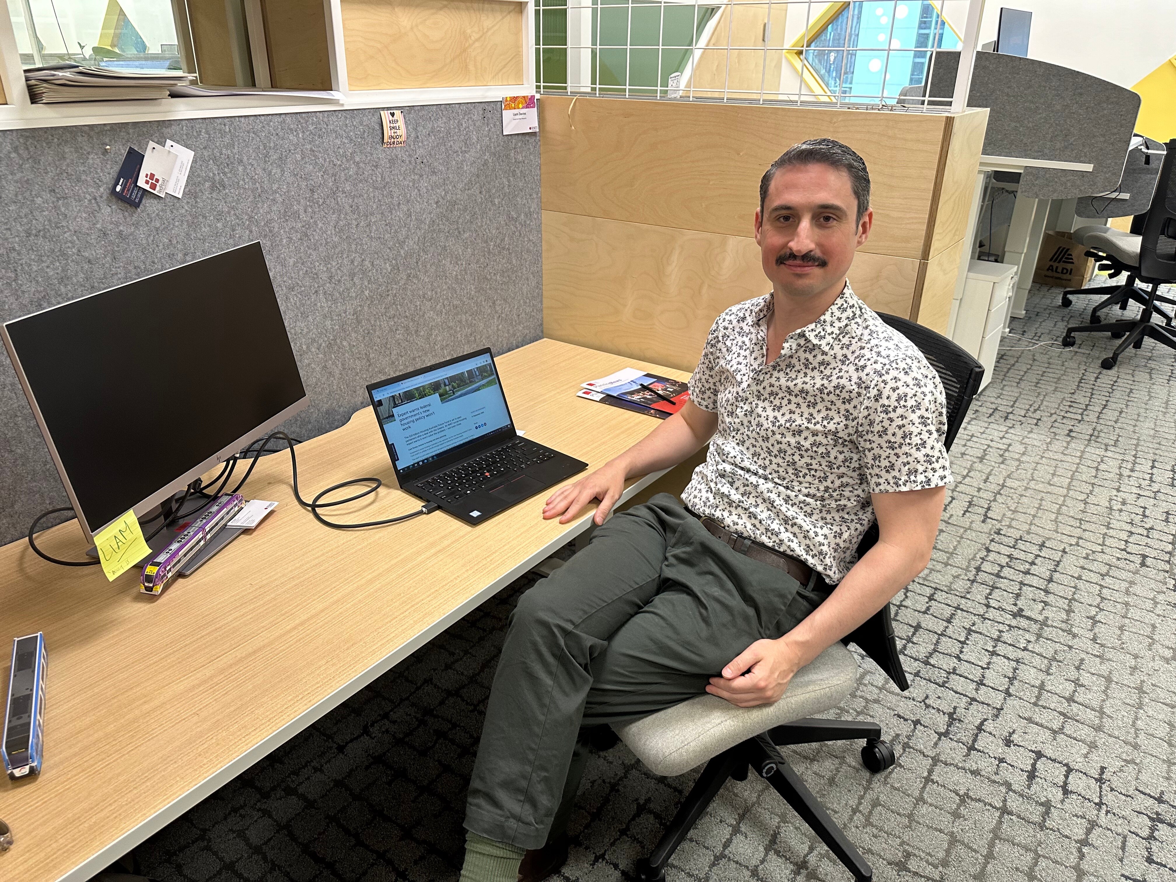 A man sitting at a desk inside a modern university