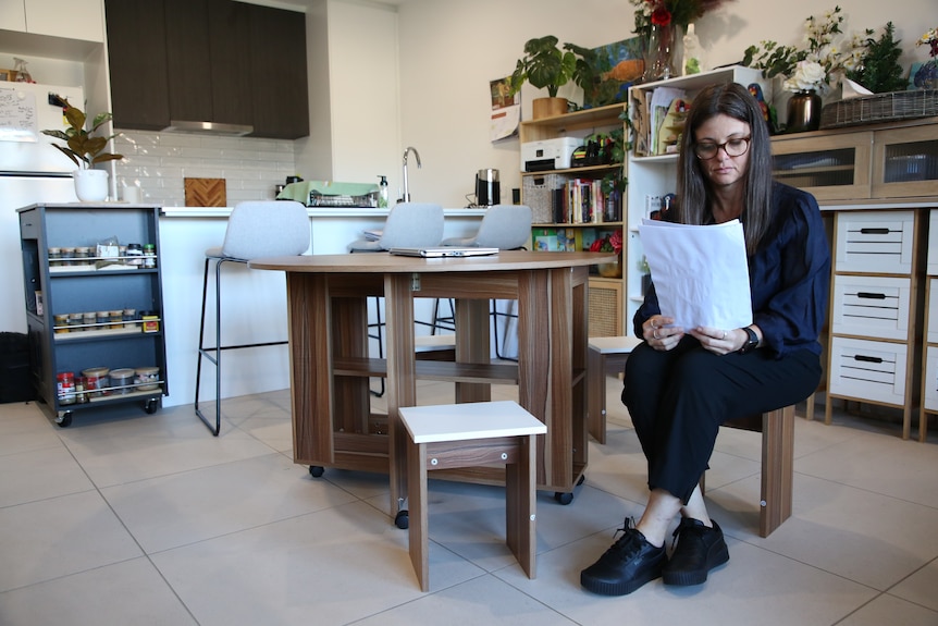 A woman reading in her kitchen