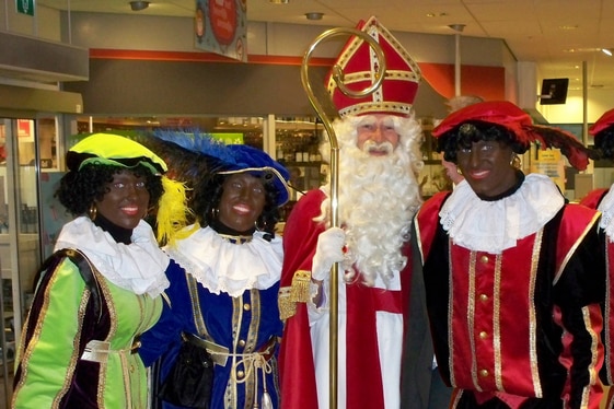 Dutch Santa poses with his Black Petes in a Dutch cultural tradition.
