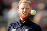 Ben Stokes throws a white ball in the air in a one-day international match.
