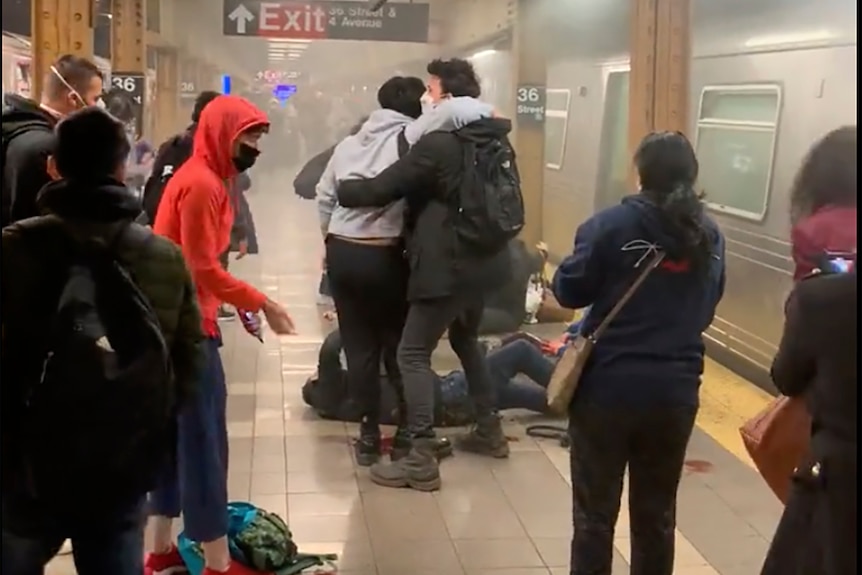 People hug on a smokey train platform.