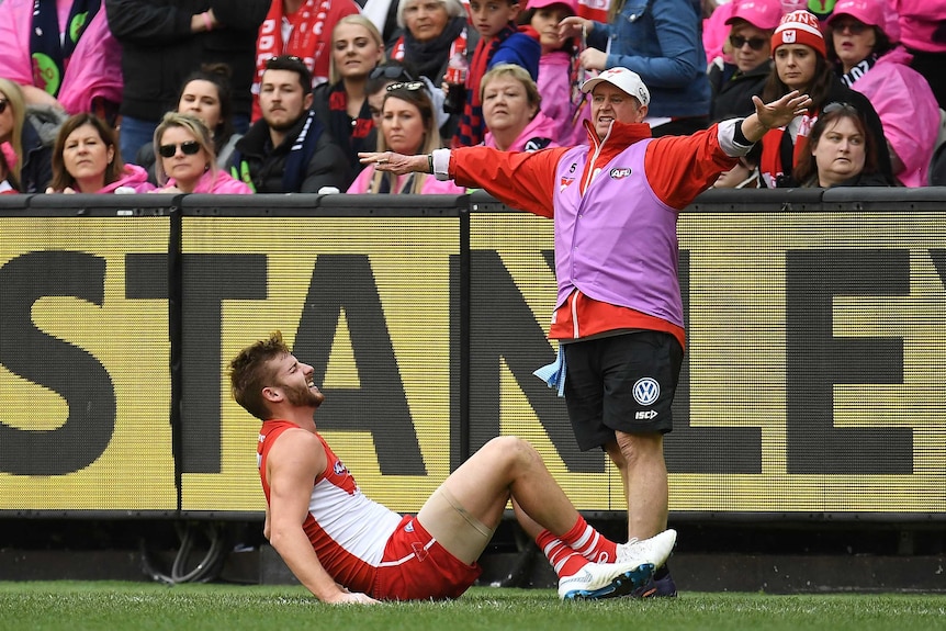 Alex Johnson on the ground after injuring his knee in the Swans' win over the Demons at the MCG.