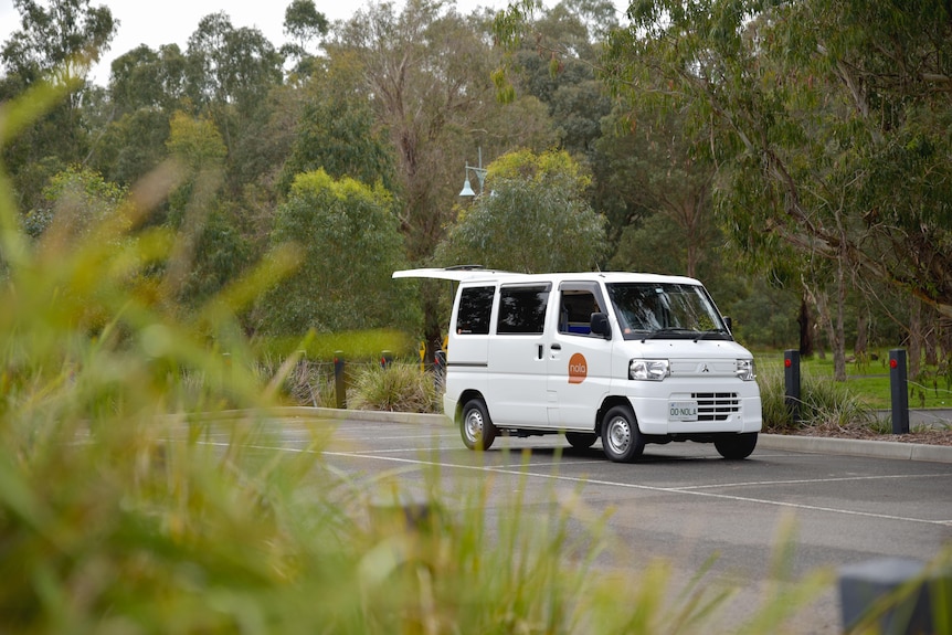 A white coffee van parked near a local park.