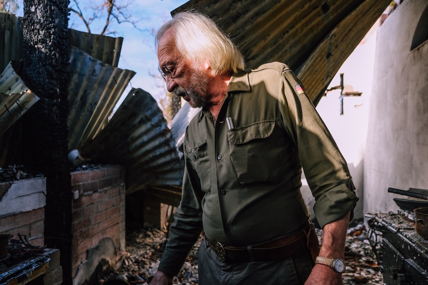 Stefan Talmatzky looks at the charred remains of his home which was destroyed by bushfire.