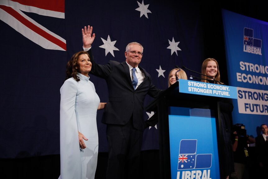 Scott Morrison stands on stage with his wife, Jenny, and two daughters.