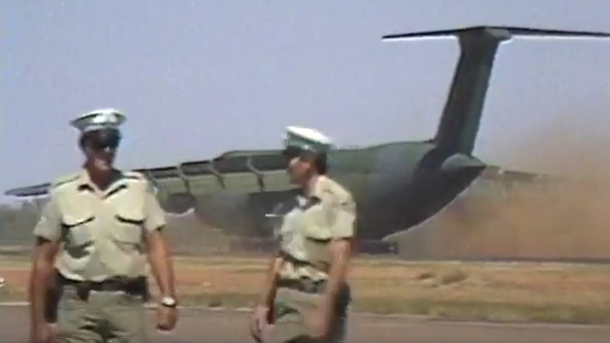 Police standing in front of Galaxy C5 as it lands in central Australia