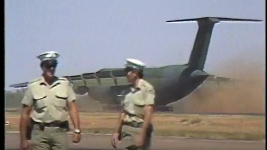 Police standing in front of Galaxy C5 as it lands in central Australia