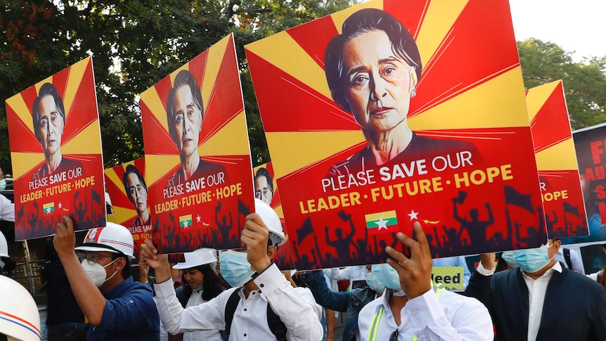 Anti-coup protesters in Myanmar are seen holding up signs showing Aung San Suu Kyi.
