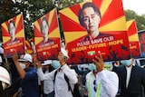 Anti-coup protesters in Myanmar are seen holding up signs showing Aung San Suu Kyi.