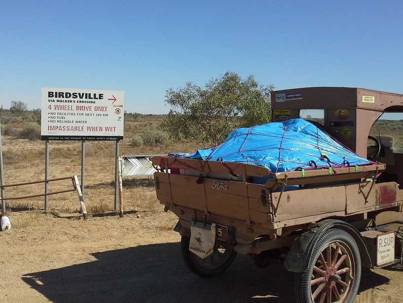 Norm Morgan's vintage car passes a sign to Birdsville warning the road is only suitable for four wheel drive vehicles