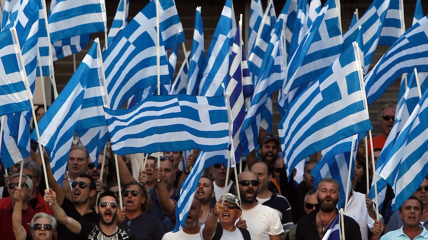 Golden Dawn supporters wave Greek national flags and shout slogans outside police headquarters in Athens.