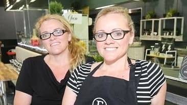 Two women in a cafe smiling