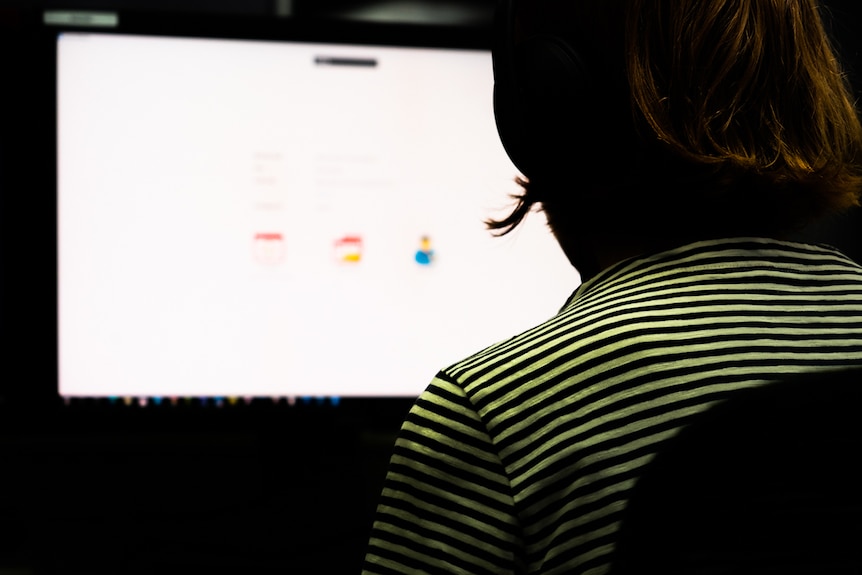 A woman looks at a computer screen.