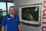 Man stands next to fish tank