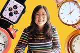 Jennifer Wong surrounded by four large watches and clocks on a yellow background.