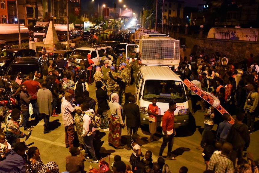 晚上，汽车和人群聚集在马路中间。