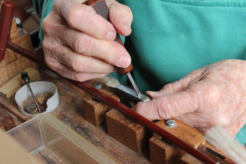 Close up on a pair of hands working with tools.