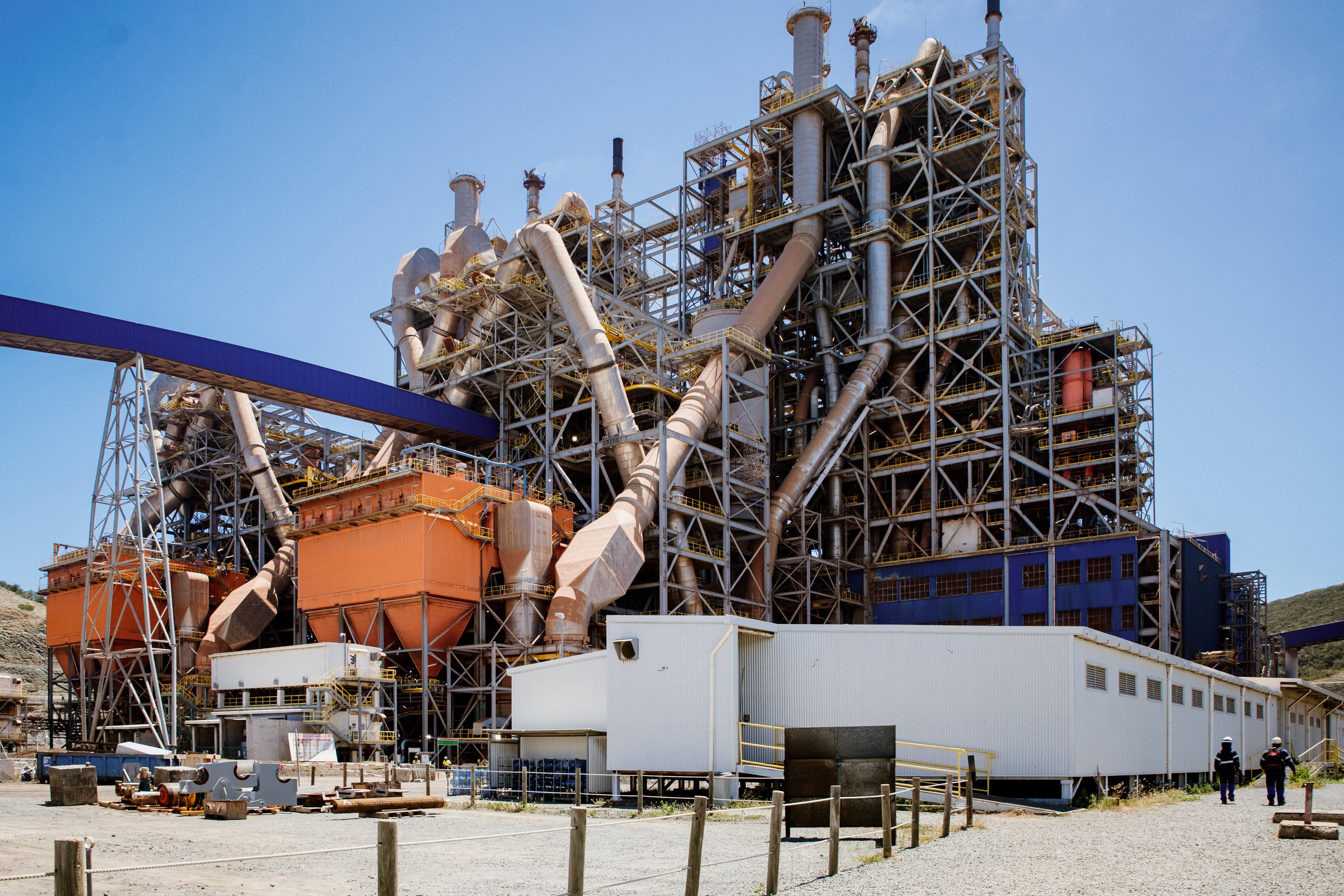 A tall industrial building of metal pipes and chutes.
