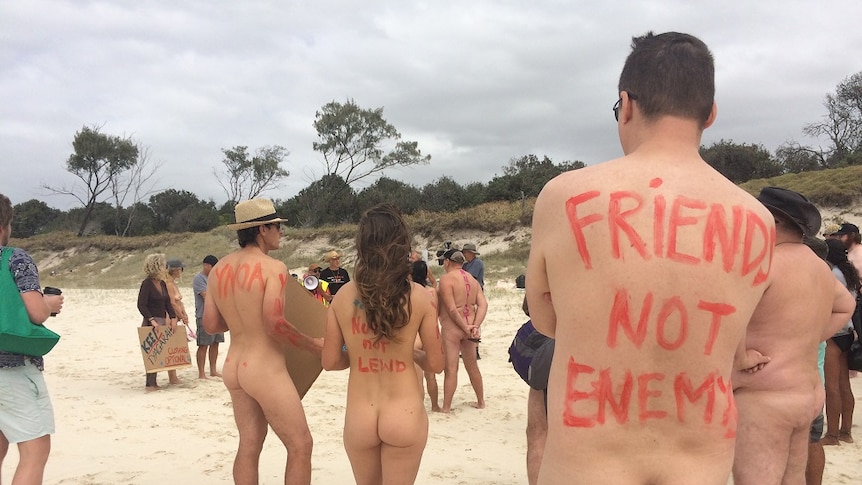Naked protesters hold placards at a beach north of  Byron Bay