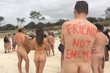 Nudists with slogans painted on their backs attend a protest rally near Byron Bay.