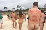 Naked protesters hold placards at a beach north of  Byron Bay