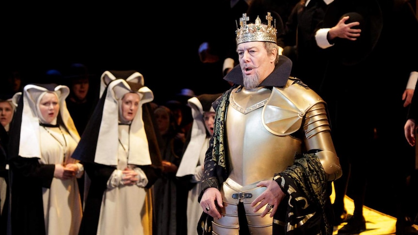 Italian bass Ferruccio Furlanetto wearing gold armour and a crown, nuns in the background.