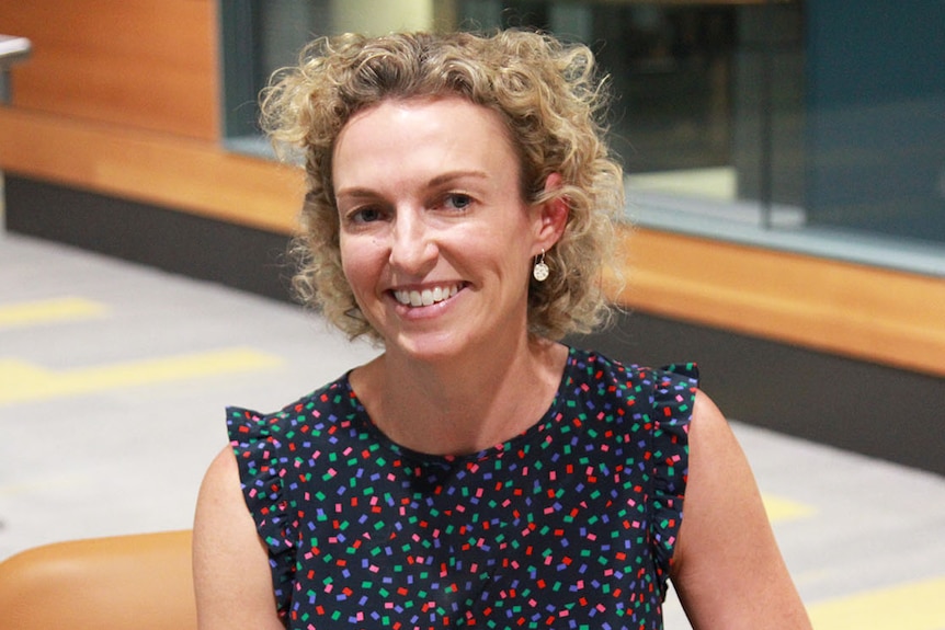 Careers coach Leah Lambart sits in a chair and smiles.