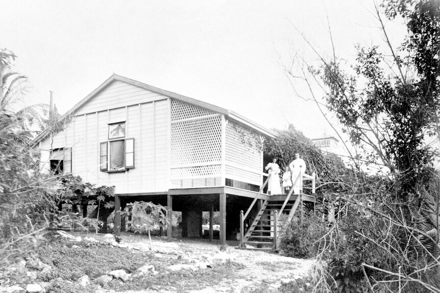 Archival image, wide-shot, black and white, of family standing on steps of Banaba island house.