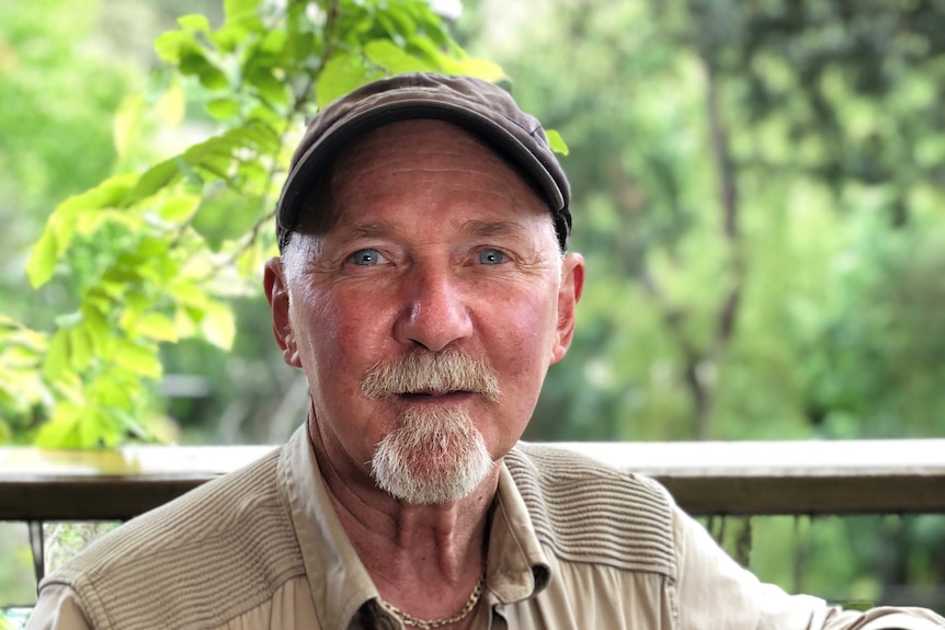 A man wearing a cap looking at the camera