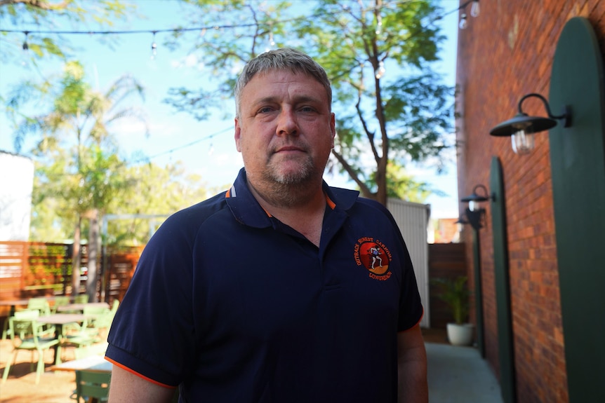 Man in navy shirt staring at camera.